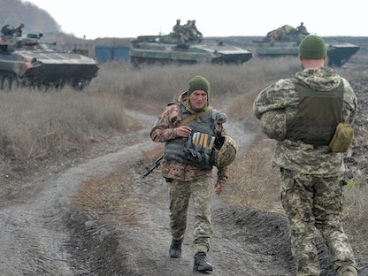 جنود أوكرانيون يستعدون لركوب ناقلات جند مدرعة (APC) في منطقة فض الاشتباك بالقرب من خط التماس مع المتمردين الانفصاليين المدعومين روسياً في دونيتسك - 9 نوفمبر2019 - REUTERS