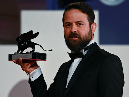 المخرج الإيراني هومان سيدي مع جائزة قسم آفاق لأفضل فيلم  بمهرجان فينيسيا - 10 سبتمبر 2022  - AFP