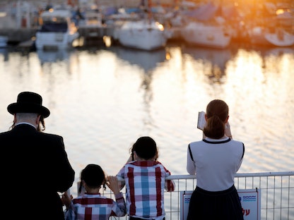 عائلة يهودية تقف أمام إحدى المرافق السياحية في تل أبيب - REUTERS