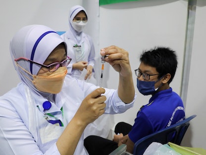 ممرضة تحضر جرعة من لقاح فايزر ضد كورونا لطالب في مدرسة ثانوية في بوتراجايا، ماليزيا. 20 سبتمبر 2021 - REUTERS