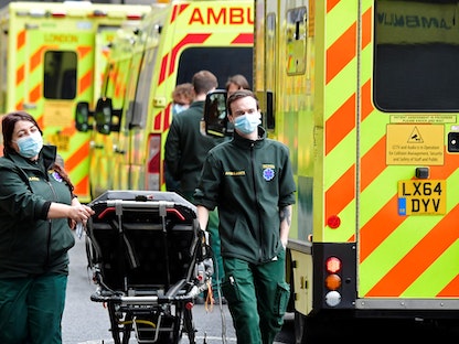 عاملون صحيون خارج مستشفى لندن الملكي في لندن خلال عملهم وقت جائحة كورونا - REUTERS