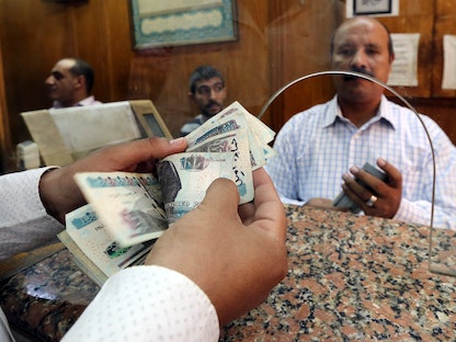 موظف في أحد البنوك بالعاصمة المصرية القاهرة يحسب نقود بالعملة المحلية. 3 نوفمبر 2016 - REUTERS