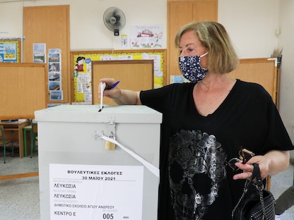 ناخبة تدلي بصوتها داخل صندوق، خلال الانتخابات البرلمانية في مركز اقتراع بالعاصمة القبرصية نيقوسيا. 30 مايو 2021 - REUTERS