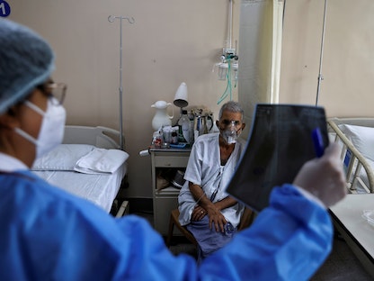طبيبة تفحص صورة بالأشعة السينية لمريض مصاب بفيروس كورونا داخل مستشفى في نيودلهي، الهند- 1 مايو 2021 - REUTERS