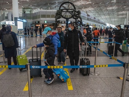 مسافرون يرتدون أقنعة للوقاية من فيروس كورونا في مطار بكين. 14 يناير 2023 - Bloomberg