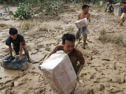 ناجون يحملون مواد إغاثة وسط تداعيات قاسية للفيضانات في كارانج بارو، إقليم آتشيه تاميانج، محافظة آتشيه، إندونيسيا. 6 ديسمبر 2025 - Reuters