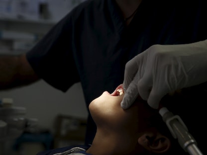 طبيب أسنان يعالج صبياً في مستوصف أطباء العالم وسط أثينا اليونان. 27 أكتوبر 2015 - REUTERS