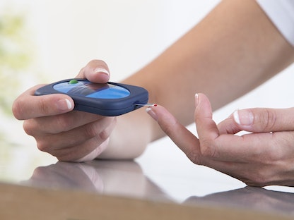 سيدة تجري اختباراً لقياس نسبة السكر في الدم. - Getty Images