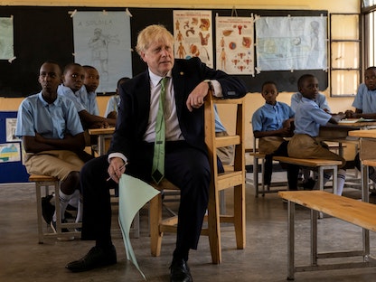 رئيس الوزراء البريطاني بوريس جونسون خلال زيارته لإحدى المدارس على هامش اجتماع "الكومنولث" في كيجالي - 23 يونيو 2022. - REUTERS