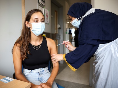 شابة تتلقى جرعة من لقاح مضاد لكورونا في مستشفى ميدلسكس المركزي بلندن - 1 أغسطس 2021 - REUTERS