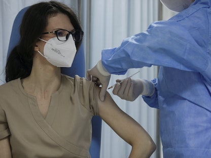 ممرضة تتلقى تلقيحاً في مركز طبي ببوخارست - رومانيا - 27 ديسمبر 2020 - REUTERS