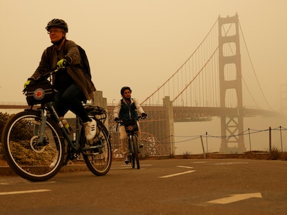 دراجان أميركيان قرب "جسر البوابة الذهبية" في كاليفورنيا يقودان وسط الدخان المتصاعد من حرائق الغابات في سان فرانسيسكو، 10 سبتمبر 2020 - REUTERS
