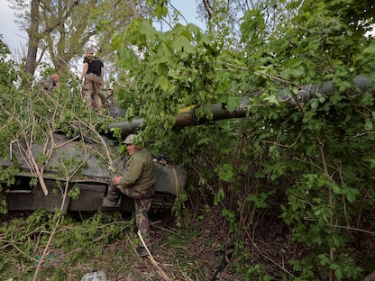 جنود أوكرانيون قرب دبابة من طراز "تي-80" استولوا عليها من القوات الروسية في خاركوف - 1 مايو 2022 - REUTERS