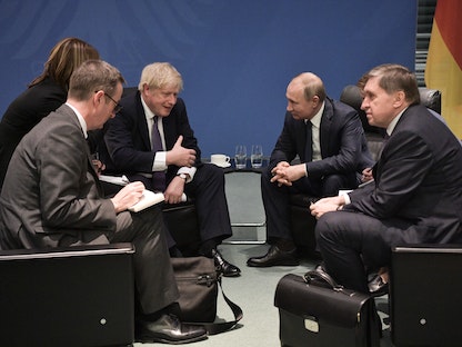 رئيس الوزراء البريطاني بوريس جونسون والرئيس الروسي فلاديمير بوتين يلتقيان على هامش قمة السلام حول ليبيا في برلين، 19 يناير 2020 - AFP