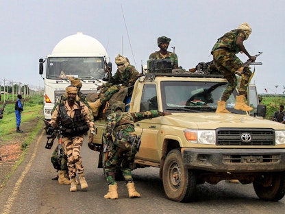 مقاتلون يخرجون من مركبة في قافلة عسكرية ترافق حاكم ولاية دارفور في السودان خلال توقف في شرق القضارف أثناء توجههم إلى بورتسودان. 30 أغسطس 2023 - AFP