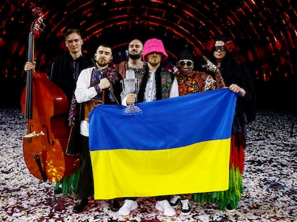 أعضاء فرقة "أوركسترا كالوش" يرفعون علماً أوكرانياً بعد فوزهم في مسابقة "يوروفيجن" للأغاني الأوروبية في تورينو - 15 مايو 2022 - REUTERS