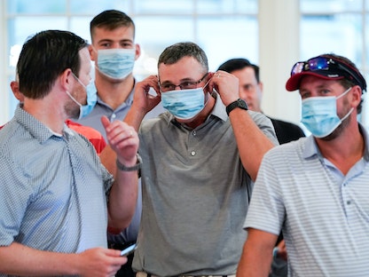 أميركيون يرتدون كمامات للوقاية من فيروس كورونا - REUTERS