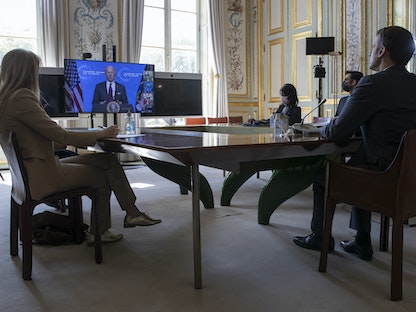 الرئيس الفرنسي إيمانويل ماكرون يستمع إلى الرئيس الأميركي جو بايدن خلال قمة المناخ الافتراضية، 22 أبريل 2021 - AFP