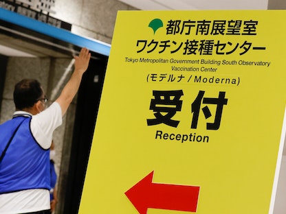 لافتة لحملة التطعيم ضد فيروس كورونا بلقاح "مودرنا" في مبنى حكومة العاصمة طوكيو، اليابان - 25 يونيو 2021. - REUTERS