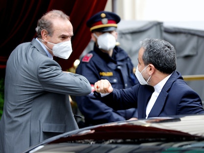 رئيس بعثة إيران إلى محادثات فيينا عباس عراقجي، مع مبعوث الاتحاد الأوروبي  إنريكي مورا - فيينا - 25 مايو 2021 - REUTERS