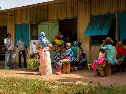 أمهات يصطففن للكشف على أطفالهن في مركز صحي بمدينة باوا في جمهورية إفريقيا الوسطى - 3 ديسمبر 2021 - AFP