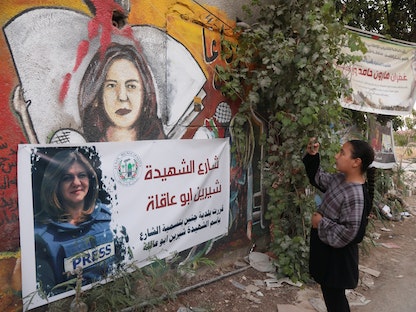 فتاة فلسطينية تلتقط صورة لمكان قتل الصحافية شيرين أبو عاقلة - 3 يونيو 2022 - REUTERS