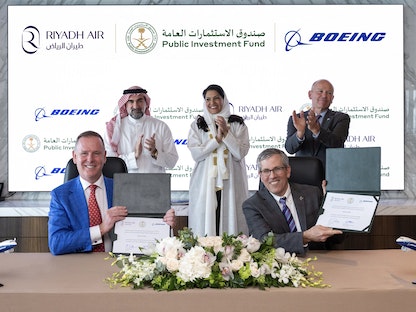 المدير التنفيذي لبوينج ديفيد كالهون (يمين)، وسفيرة السعودية لدى واشنطن الأميرة ريما بنت بندر بن سلطان (وسط) ومحافظ صندوق الاستثمارات العامة السعودي ياسر الرميان (يسار) يشهدون توقيع اتفاق طلب طائرات بوينج - twitter/PIFSaudi