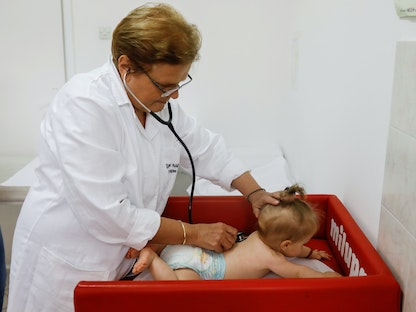 طبيبة تفحص طفلاً في مستشفى بعاصمة صربيا بلجراد. 3 سبتمبر 2018 - REUTERS