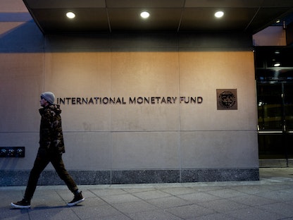شخص يمر أمام مقر صندوق النقد الدولي في واشنطن العاصمة- 10 يناير 2022. - AFP