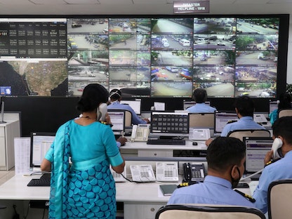 موظفون يتابعون شاشات مراقبة داخل غرفة إدارة الكوارث لمتابعة حركة الأشخاص على الطرق وتوافر الأسرة في المستشفيات بجميع أنحاء مومباي. 18 مايو- 2021. - REUTERS