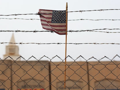 علم الولايات المتحدة خلف الأسلاك الشائكة في قاعدة ساثر الجوية السابقة بالقرب من العاصمة العراقية بغداد. - Reuters