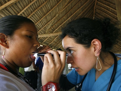 طبيبة تفحص فم امرأة في الهند. 20 أكتوبر 2008 - REUTERS