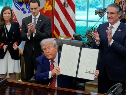 الرئيس الأميركي دونالد ترمب يحمل أمراً تنفيذياً موقعاً في البيت الأبيض بالعاصمة واشنطن- 23 مايو 2025 - Reuters