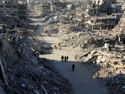 فلسطينيون يسيرون وسط ركام المنازل التي دمرتها الحرب الإسرائيلية في مدينة رفح جنوب قطاع غزة. 20 يناير 2025 - REUTERS
