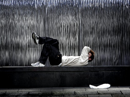 رجل مستلقي في أحد شوارع سيدني الأسترالية. 20 مارس 2005 - REUTERS