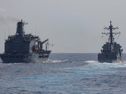 مدمرة الصواريخ الأميركية الموجهة "USS Milius" أثناء عملية إمداد وتموين في بحر الصين الجنوبي. 6 أبريل 2023 