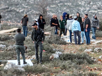 جنود إسرائيليون مع مستوطنين حاولوا إعادة إنشاء بؤرة استيطانية تسمى أور حاييم شمالي الضفة الغربية المحتلة، 22 يناير 2023 - AFP