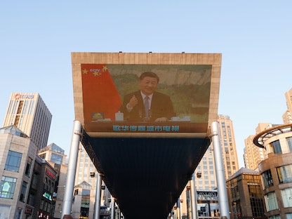 الرئيس الصيني يظهر على شاشة عملاقة ضمن تقرير إخباري يتحدث عن اللقاء مع رئيسة مفوضية حقوق الإنسان الأممية ميشيل باشليه - REUTERS