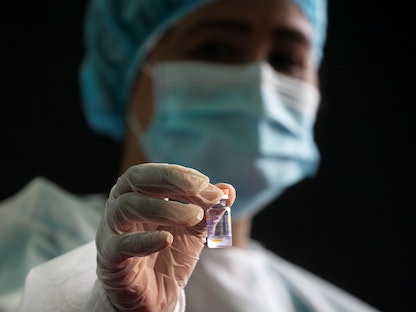 عاملة طبية في تحمل قارورة من لقاح "سينوفاك" الصيني - REUTERS