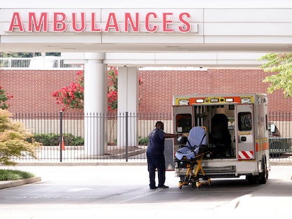 سائق سيارة إسعاف يقوم بتطهير نقالة بعد نقل مصاب بفيروس كورونا إلى مستشفى في ممفيس بالولايات المتحدة- 13 أغسطس 2021 - REUTERS