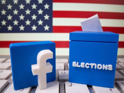 شعار "فيسبوك" وصندوق انتخابات، مطبوعان بشكل ثلاثي الأبعاد، موضوعان على لوحة مفاتيح كمبيوتر أمام علم أميركي - 6 أكتوبر 2020 - REUTERS