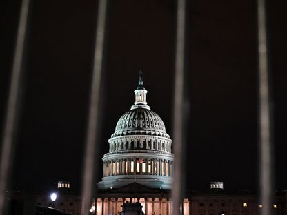 مبنى الكابيتول الأميركي يظهر من خلال قضبان أحد الحواجز ليلاً في العاصمة واشنطن. 17 فبراير 2022 - REUTERS
