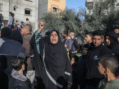 فلسطينيون بجوار أنقاض مبان دمرتها الغارات الإسرائيلية في مدينة رفح بجنوب قطاع غزة. 3 مارس 2024 - AFP