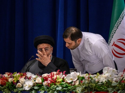 الرئيس الإيراني إبراهيم رئيسي يستمع إلى أحد مساعديه خلال مؤتمر صحافي في نيويورك. 22 سبتمبر 2022 - AFP