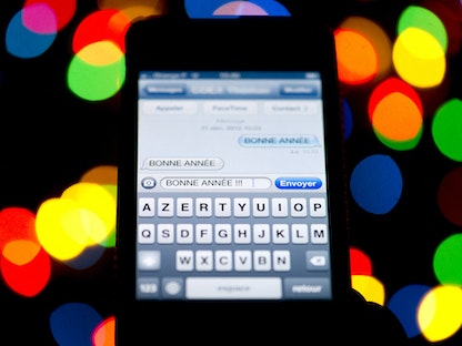 رسالة نصية (SMS) باللغة الفرنسية عبارة عن تهنئة بالعام الجديد على هاتف ذكي في باريس - 31 ديسمبر 2012. - AFP