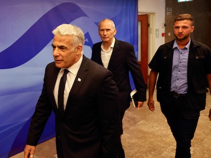 يائير لبيد يصل إلى مقر الحكومة الإسرائيلية لحضور الاجتماع الأسبوعي للحكومة- 26 يونيو 2022 - AFP