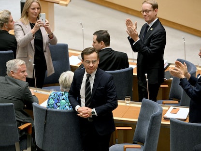 نائبان يصفقان لكريسترسون بعد تعيينه رئيساً لوزراء السويد في استوكهولم - 17 أكتوبر 2022 - REUTERS