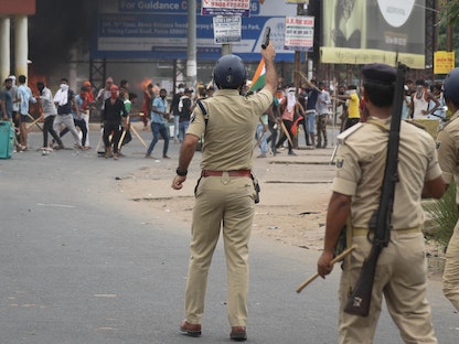 شرطي يطلق النار في الهواء خلال احتجاجات على خطة للتجنيد العسكري في باتنا بولاية بيهار الهندية- 17 يونيو 2022 - REUTERS