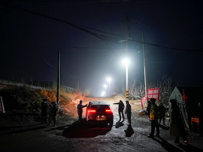 عناصر أمن يراقبون مدخل منجم ذهب في الصين حيث حوصر عمال تحت الأرض بعد انفجار قبل عشرة أيام، 21 يناير 2021 - REUTERS