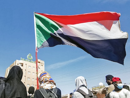 متظاهرون يحملون علم السودان في العاصمة الخرطوم - 4 يناير 2022 - AFP